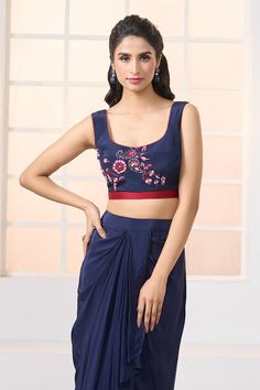 Navy blue cropped jacket with semi-sheer sleeves featuring multi colored floral and paisley hand embroidery with sequin highlights. Comes with a matching embroidered bustier, a plain dhoti skirt and a plain pre-pleated draped dupatta. Paired with floral embroidered belt and a coordinating potli bag. - Aza Fashions Blue Fitted Cropped Sets, Blue Sleeveless Blouse Crop Top, Elegant Sleeveless Blue Crop Top, Elegant Blue Sleeveless Crop Top, Blue Padded Blouse Choli For Party, Blue Padded Choli For Party, Fitted Sleeveless Silk Choli, Fitted Cropped Choli For Party, Fitted Cropped Choli For Festive Occasions