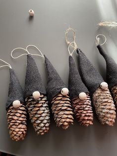 five pine cone ornaments are lined up in a row on a table with twine string