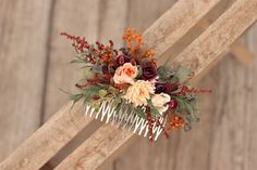 a comb decorated with flowers and foliage on top of a wooden chair next to a wall