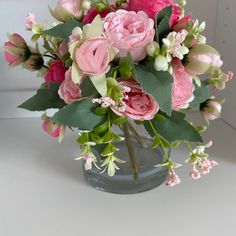 a vase filled with pink flowers on top of a table