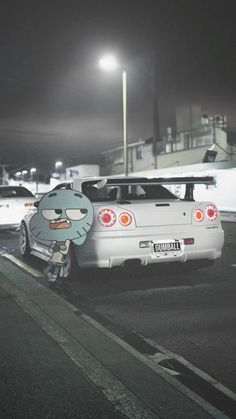 a white car parked on the side of a road at night with cartoon characters painted on it