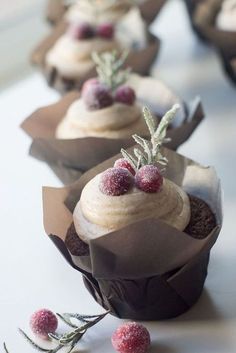 some cupcakes with frosting and berries on them