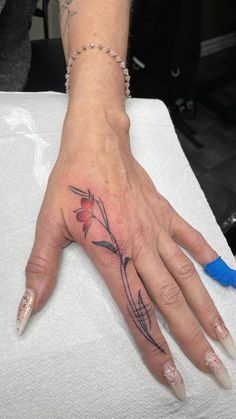 a woman's hand with a flower tattoo on it