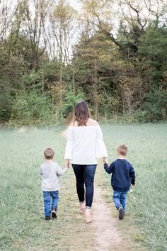 a woman and two children walking down a path