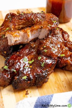 two pieces of meat sitting on top of a cutting board next to a jar of ketchup