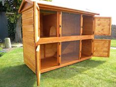 a large wooden chicken coop in the grass