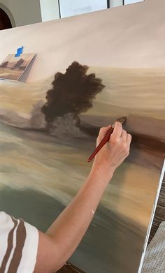 a man is painting an abstract landscape with brown and black colors on the canvass