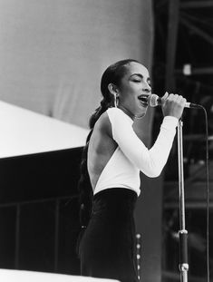 an image of a woman singing on stage with a microphone in front of her and the caption above it