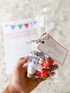 a hand holding a bag filled with lots of candy