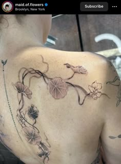 the back of a woman's shoulder with flowers on it