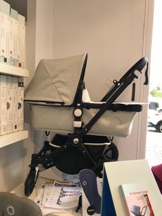 a baby stroller sitting on top of a table next to a book shelf with books