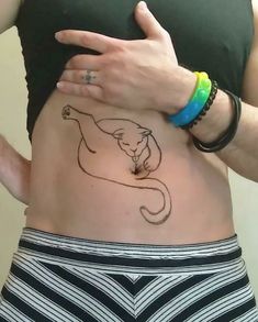 a woman's stomach with a cat tattoo on her belly and the outline of a cat