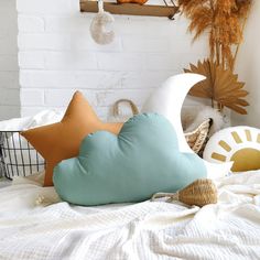 pillows and other decorative items on a bed in a room with white brick wall behind them