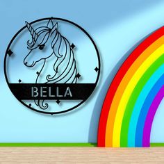 a wall with a sign that says bella and a rainbow in the corner behind it