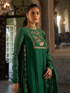 Editor's Note Introducing a stunning emerald green mallie chanderi kurta pant set, beautifully paired with a scallop-detailed dupatta. The yoke of the kurta is highlighted with an intricate anar motif using antique gold handwork, adding a touch of opulence and charm to the ensemble. Step into any special occasion with confidence, dressed in this exquisite emerald green kurta pant set that effortlessly combines traditional craftsmanship with contemporary elegance. Color: Green Fabric: Mallie chan Handwork Dress, Paulmi And Harsh, Queens University, 1950’s Fashion, Kurta Pant Set, White Maxi Skirts, A Line Kurta, Boutique Dress Designs, Party Wear Indian Dresses