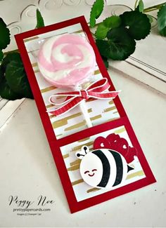 a close up of a card with a lollipop in the shape of a bee