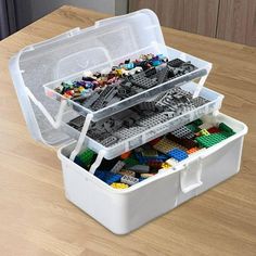 an open lego box on a wooden table with two containers filled with different types of legos