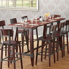 a dining room table with chairs and a vase filled with flowers on top of it