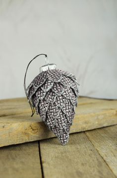 an ornament made out of woven material on a wooden table with white wall in the background