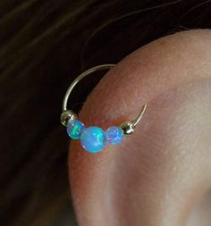 a close up view of a person's ear with opal beads