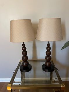 two lamps sitting on top of a glass table