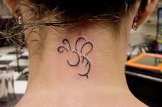 a woman's neck with a small tattoo on it