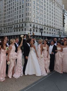 a group of people standing next to each other in front of a tall building