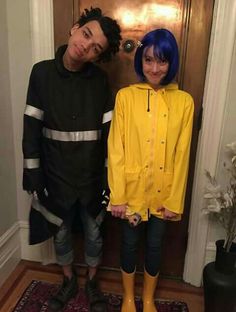 two people standing next to each other in front of a door wearing yellow rain boots