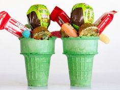 two green cups filled with candy and candies