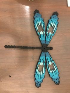 two blue and black butterflies sitting on top of a wooden table next to a clock