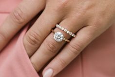 a woman's hand with two engagement rings on her finger