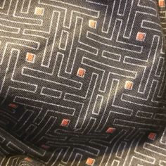 a close up view of a tie with orange and black squares on the necktie