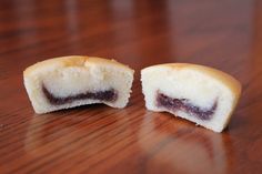 two pieces of cake sitting on top of a wooden table