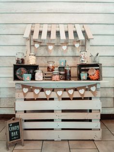 a table topped with lots of food on top of a wooden pallet next to a wall