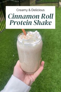 a person holding up a drink in their hand with the text creamy and delicious cinnamon roll protein shake