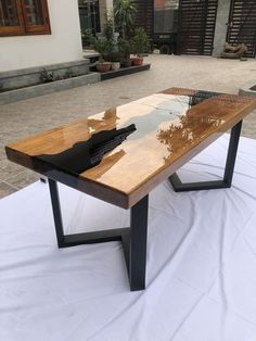 a wooden table sitting on top of a white cloth covered ground next to a building