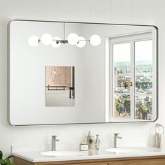 a bathroom with two sinks and a large mirror on the wall above it is shown