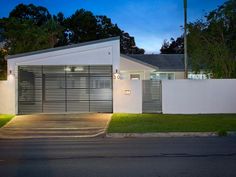 a white house with an open garage door at night