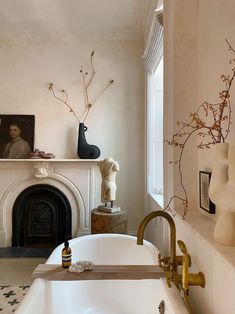 a white bath tub sitting next to a fireplace