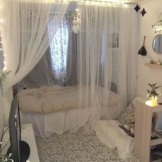 a bedroom with white curtains and lights on the ceiling