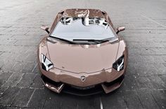 the front end of a brown sports car