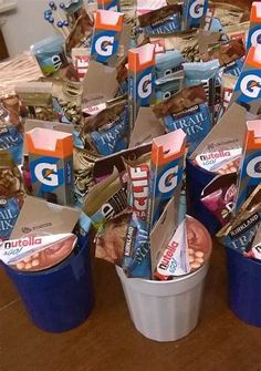 several buckets filled with snacks sitting on top of a wooden table