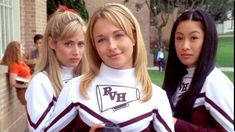 three girls in cheerleader outfits standing next to each other