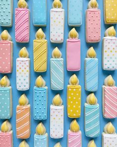 colorful cookies are arranged in rows on a blue surface with polka dots and yellow candies