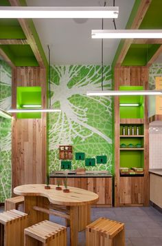 a kitchen with green painted walls and wooden furniture in the center, surrounded by shelves