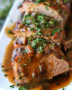 some meat is covered in gravy and garnished with parsley