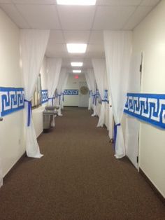 an empty hallway with white drapes on the walls and brown carpeted flooring