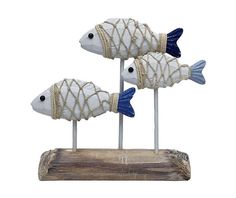 three fish on sticks with rope wrapped around the ends, sitting on top of a piece of wood