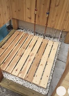 a wooden bed frame sitting next to a pool in a backyard with rocks and gravel