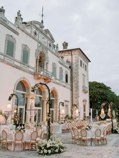 an outdoor wedding venue with tables and chairs set up in front of a large building